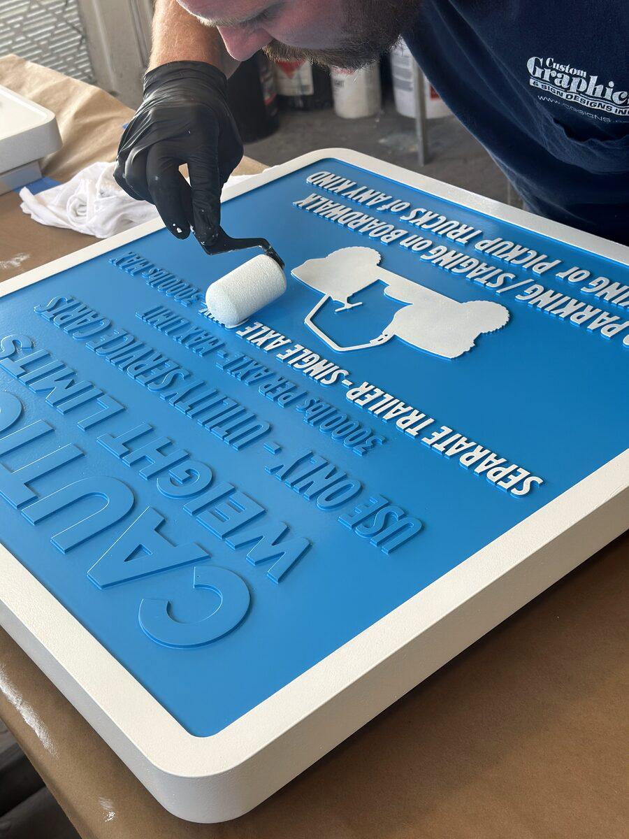 Carved HDU sign panel being hand-painted — CG Signs Orange Park FL