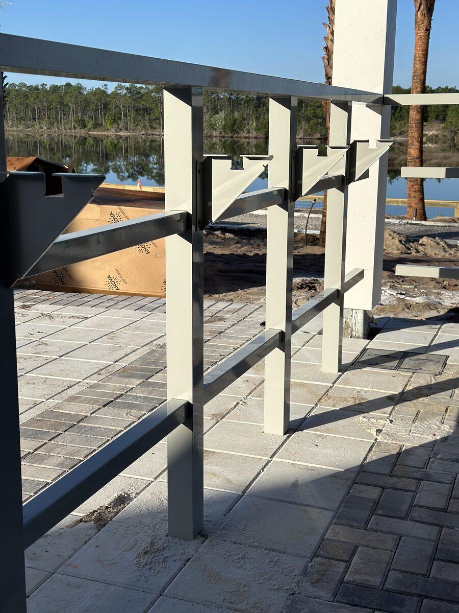 Aluminum architectural canopy brackets fabricated by CG Signs for Latitude Margaritaville Watersound, with lake view in background