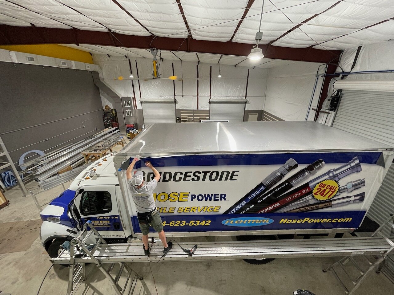 CG Signs installer wrapping a Bridgestone HosePower box truck in the Orange Park facility